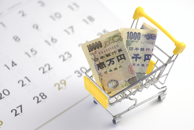 カレンダーと現金とショッピングカート